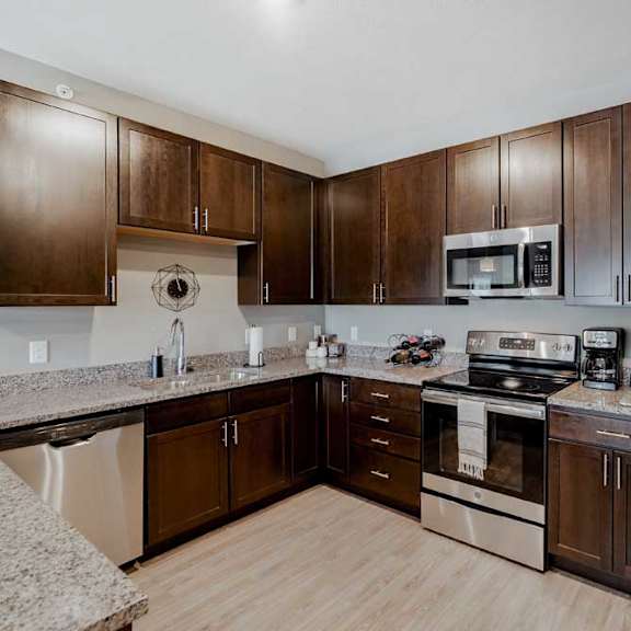 Thumbnail 5 of 17 A modern kitchen with brown cabinets and stainless steel appliances