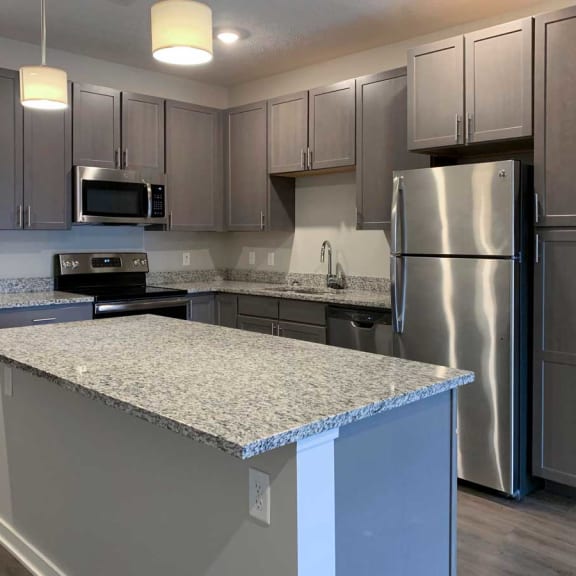 Thumbnail 2 of 13 a kitchen with stainless steel appliances and a granite counter top