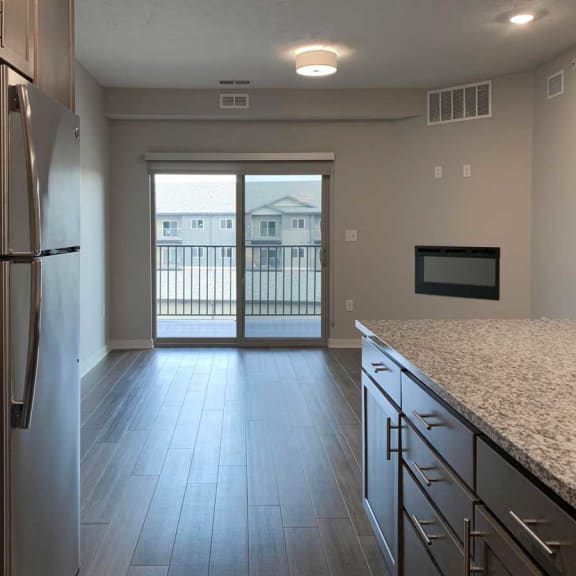 Thumbnail 3 of 13 a kitchen with a refrigerator and a door to a balcony