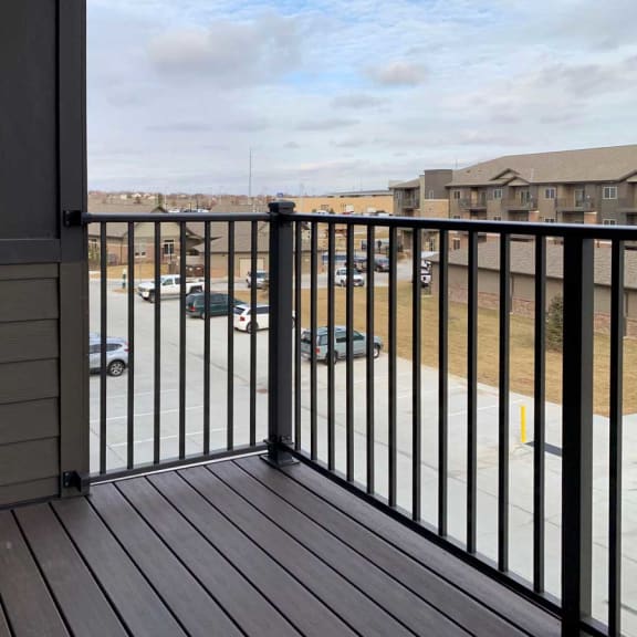 Thumbnail 7 of 13 a balcony with a view of a parking lot