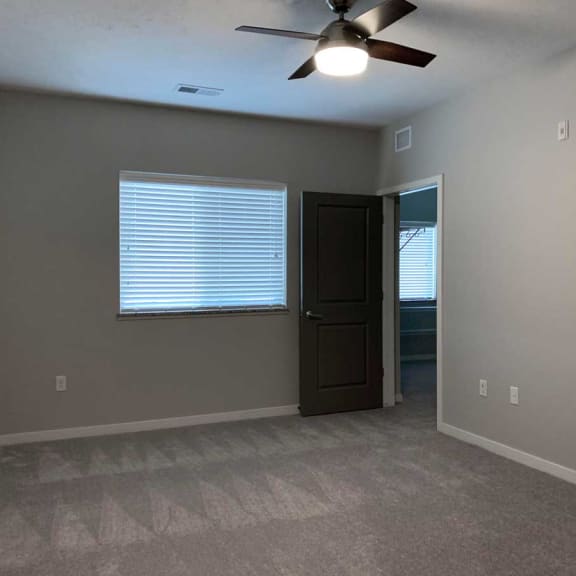 Thumbnail 5 of 13 an empty bed room with a ceiling fan and a window