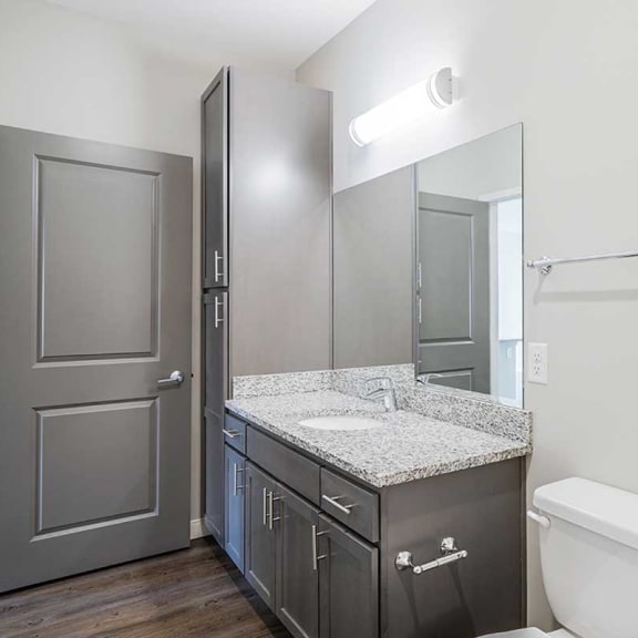 Thumbnail 19 of 19 a bathroom with a granite countertop sink and storage