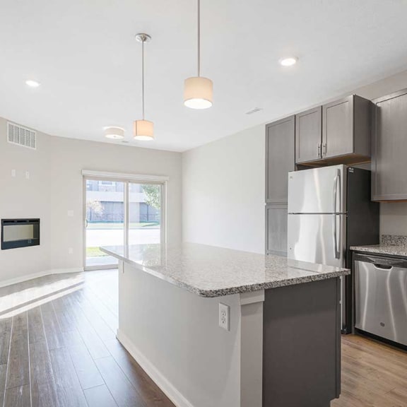 Thumbnail 7 of 19 a open-concept kitchen with stainless steel appliances and granite counter tops next to a living room