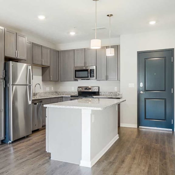 Thumbnail 4 of 19 an open kitchen with stainless steel appliances, grey cabinets, and granite counter tops