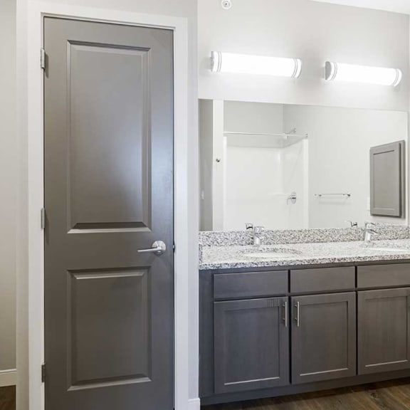 Thumbnail 17 of 27 a bathroom with a double vanity sink, a medicine cabinet, and a storage closet
