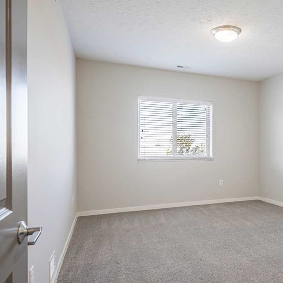Thumbnail 15 of 27 a bedroom with carpeting and natural light from a large window