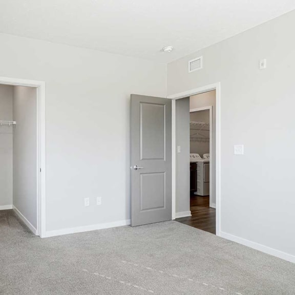 Thumbnail 22 of 27 a bedroom with a walk-in closet and carpeting