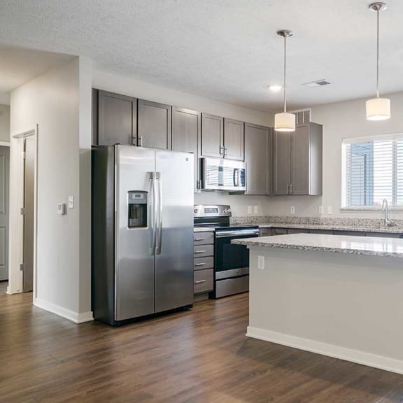 Thumbnail 10 of 27 a kitchen with stainless steel appliances, grey cabinets, and a large island