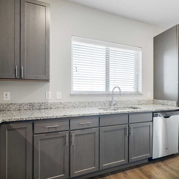 Thumbnail 12 of 27 a kitchen with stainless steel appliances, grey cabinets, and granite counter tops