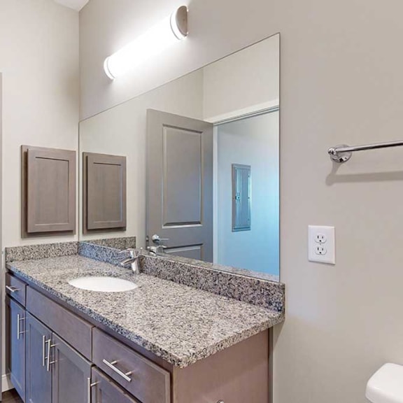 Thumbnail 27 of 29 a bathroom with a large vanity sink with granite countertop and a mirror