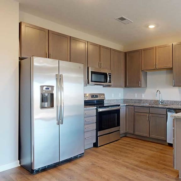 Thumbnail 4 of 29 a kitchen with stainless steel appliances, grey wooden cabinets, and a peninsula countertop