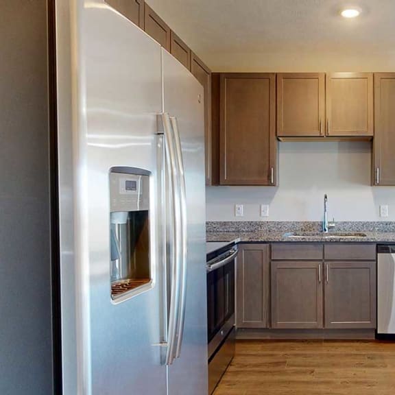 Thumbnail 6 of 29 a kitchen with stainless steel appliances and grey wooden cabinets