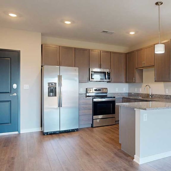 Thumbnail 8 of 29 a kitchen with grey cabinets and granite countertops featuring stainless steel appliances