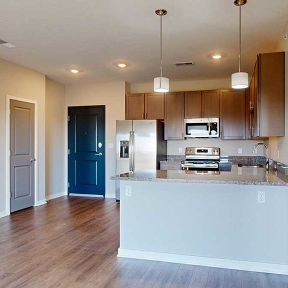Thumbnail 3 of 29 a kitchen with grey wooden cabinets next to an entry way with a coat closet