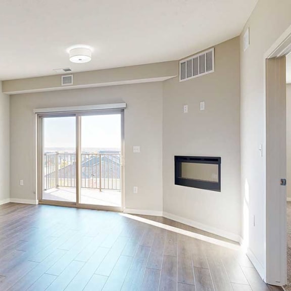 Thumbnail 11 of 29 a living room with a large sliding glass door, a fireplace, and luxury vinyl hardwood flooring