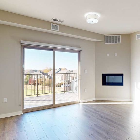 Thumbnail 10 of 29 a bright living room with a large sliding glass door and a fireplace