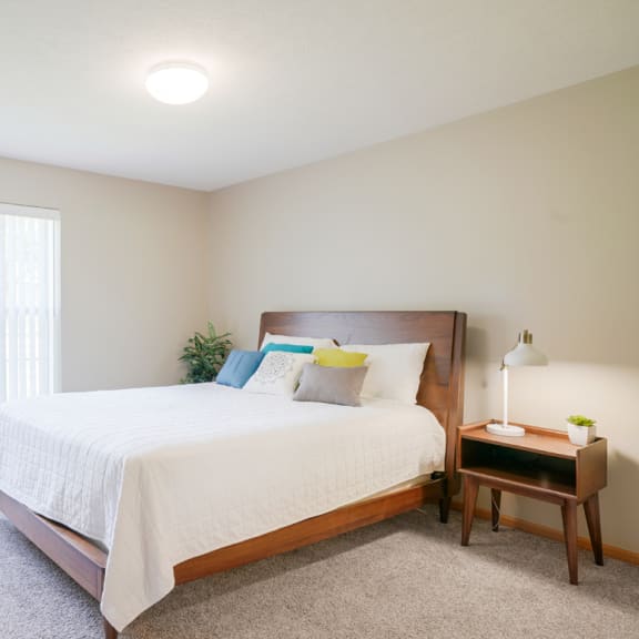 Thumbnail 10 of 20 A furnished bedroom with a large bed and a window at Williamsburg Park