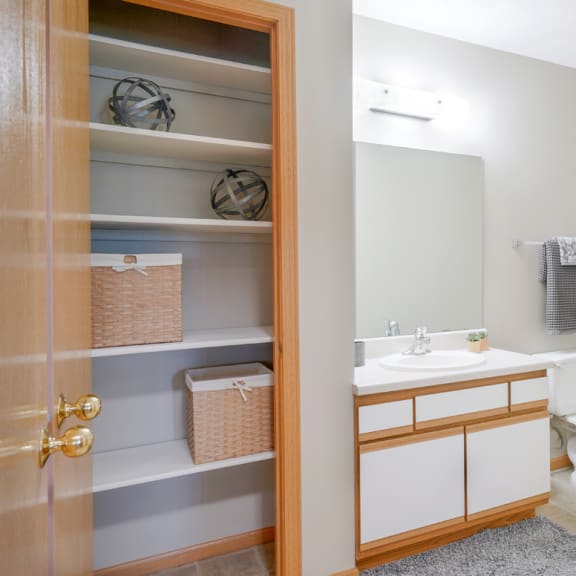 Thumbnail 13 of 20 Linen closet next to bathroom with a toilet and a sink and a mirror and shower and tub combo