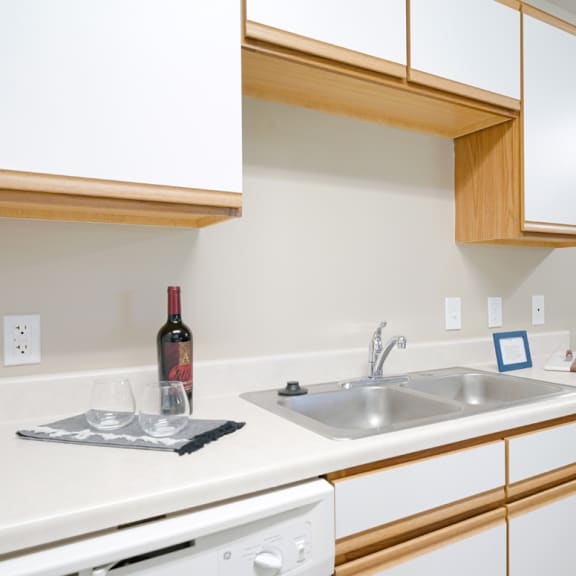 Thumbnail 9 of 20 a kitchen with a sink and a bottle of wine on the counter