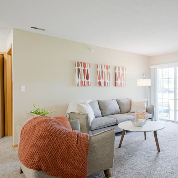 Thumbnail 2 of 20 Furnished living room with a couch and a coffee table and orange accents