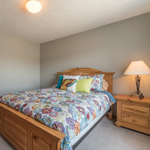 Thumbnail 9 of 10 room with bed and one nightstand with lit lamp