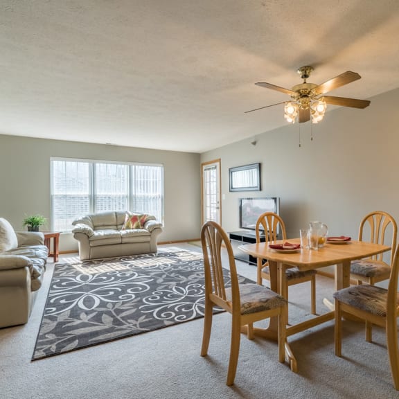 Thumbnail 5 of 10 a living room with a dining room table and a ceiling fan