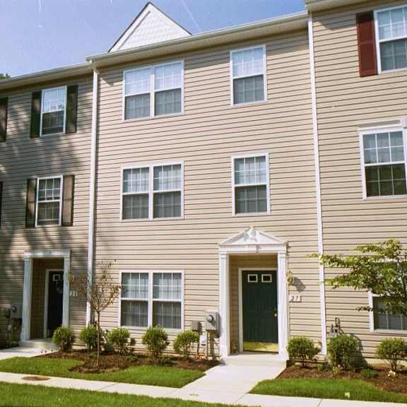 a building with two doors and a yard in front of it