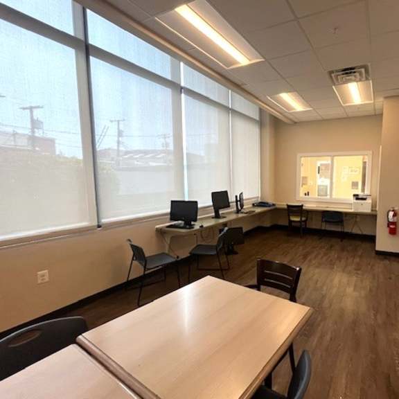 a conference room with a long table and chairs, a laptop, and a fire extinguisher.