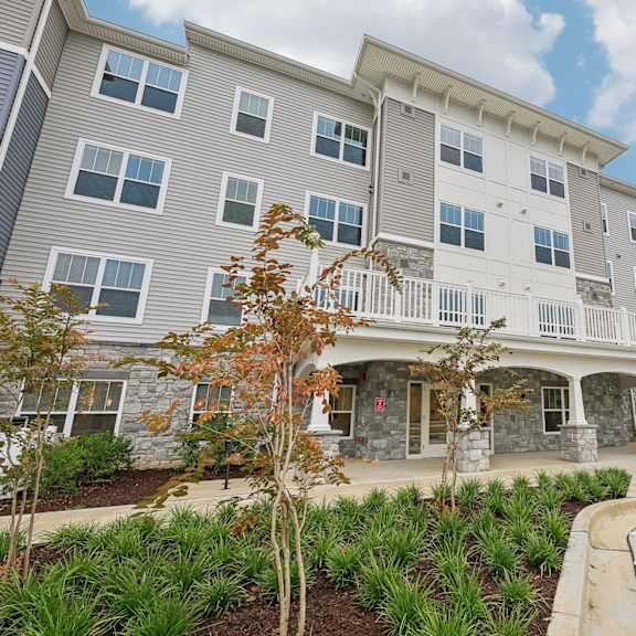 willow manor at cabin branch – senior 62+ apartment community exterior in clarksburg, md with landscaped grounds and modern architecture