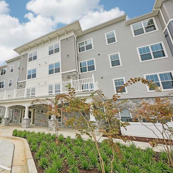 willow manor at cabin branch – senior 62+ apartment community exterior in clarksburg, md with landscaped grounds and modern architecture