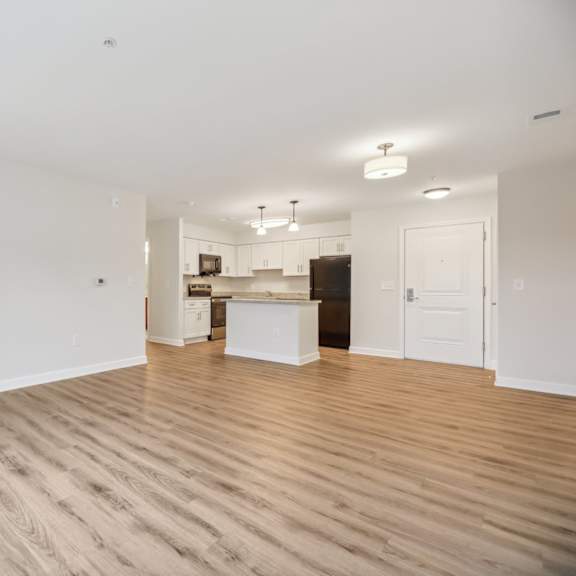 a large empty room with wooden floors and white walls.