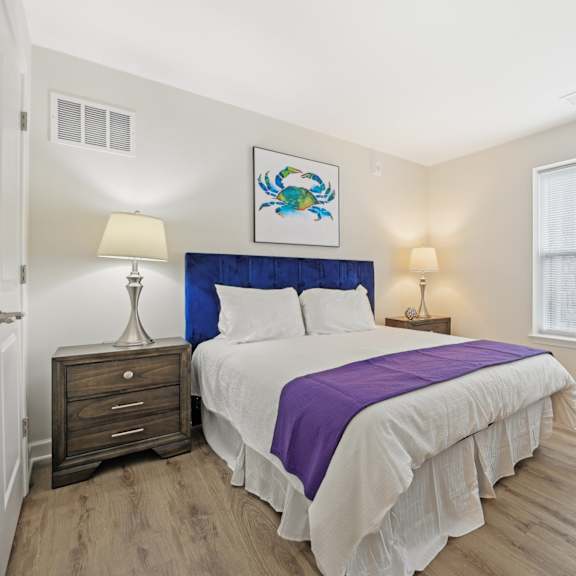 a bedroom with a bed, nightstand, and lamp.