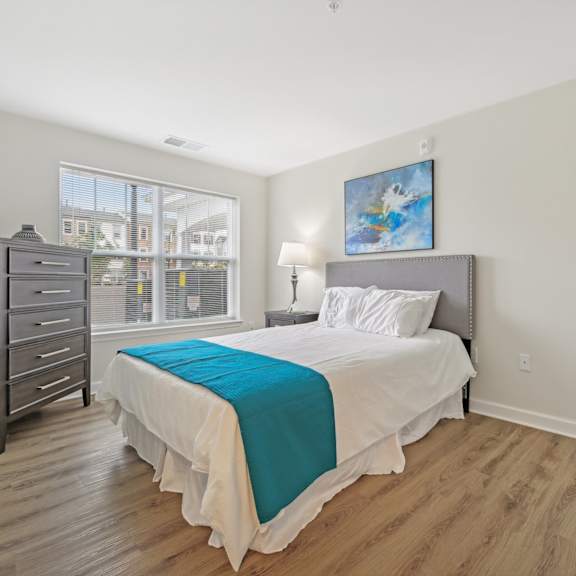 a bedroom with a bed, nightstand, and dresser.