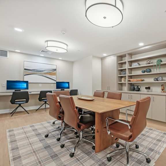 a conference room with a table, chairs, and a computer desk.