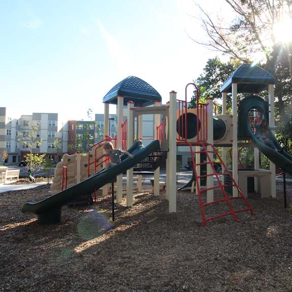 a playground with a green slide and a red ladder.