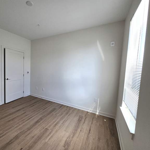 a room with a white door and a window with blinds.