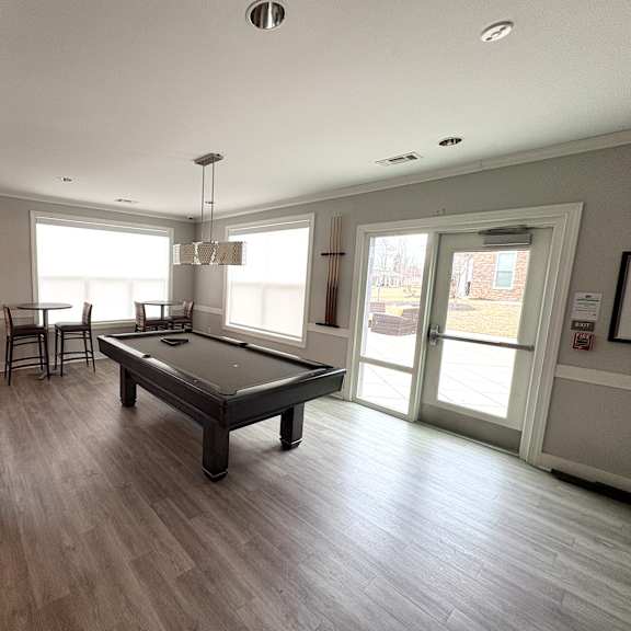 a spacious room with a pool table and a view of the outside.