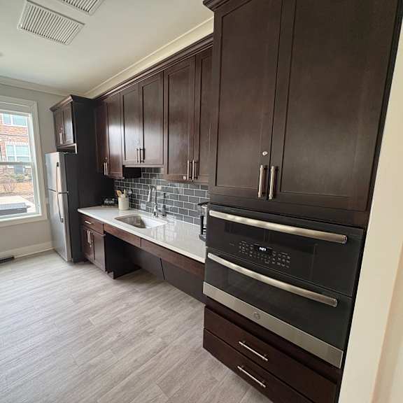 a kitchen with dark wood cabinets and a black oven.