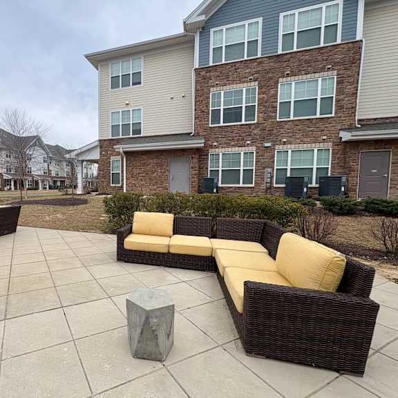 a patio with a couch and a table in front of a building.