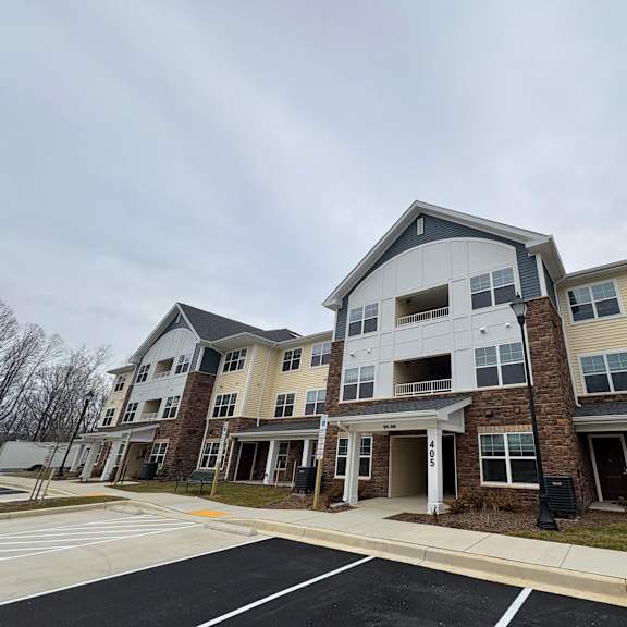 apartment complex with a parking lot in front.