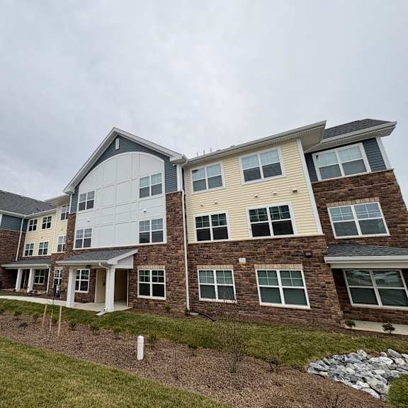 a large, multi-story residential building with a mix of brick and siding exteriors.