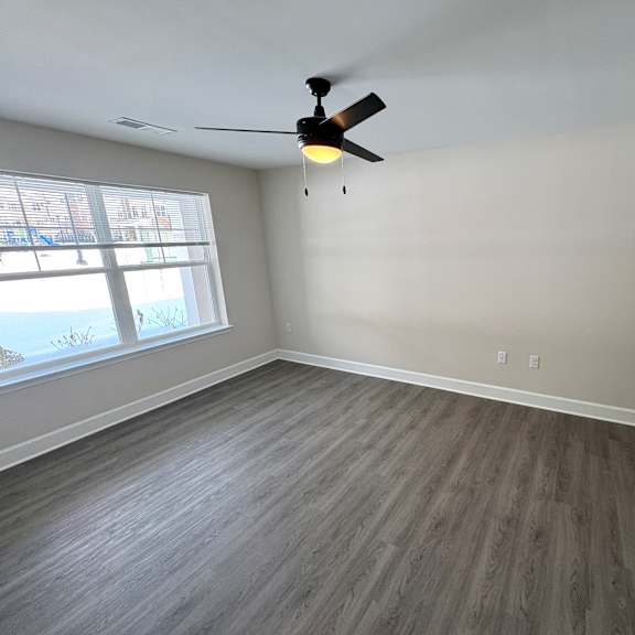 a room with a ceiling fan and a window.