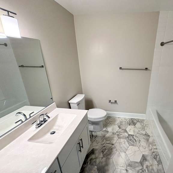 a bathroom with a marble floor and white walls.