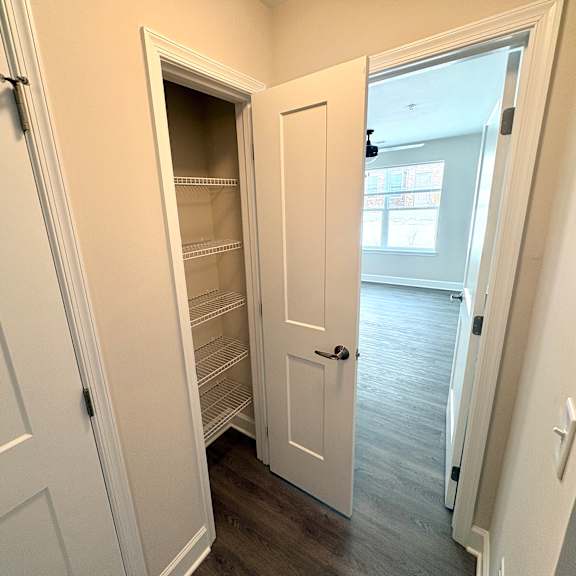 a white door is open to a room with a window.
