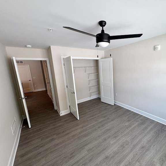 a room with a ceiling fan and a doorway leading to another room.
