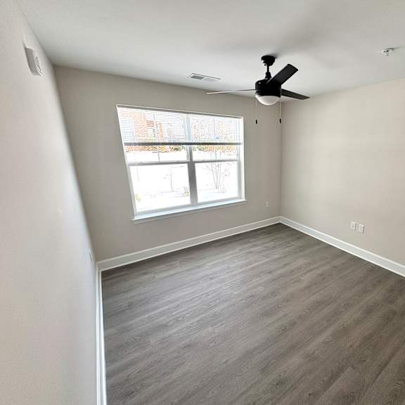 a room with a ceiling fan and a window.