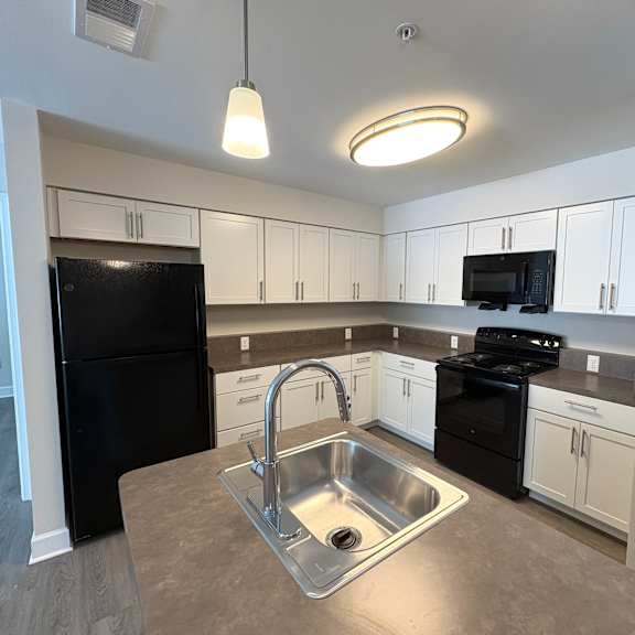 a kitchen with black appliances and white cabinets.