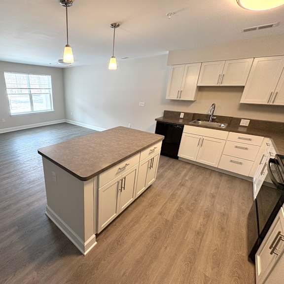 a kitchen with white cabinets and a wooden island.