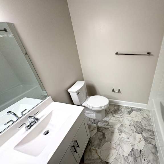 a bathroom with a marble floor and white walls.