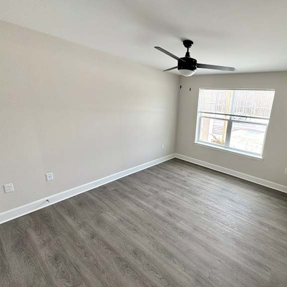 a room with a ceiling fan and a window.